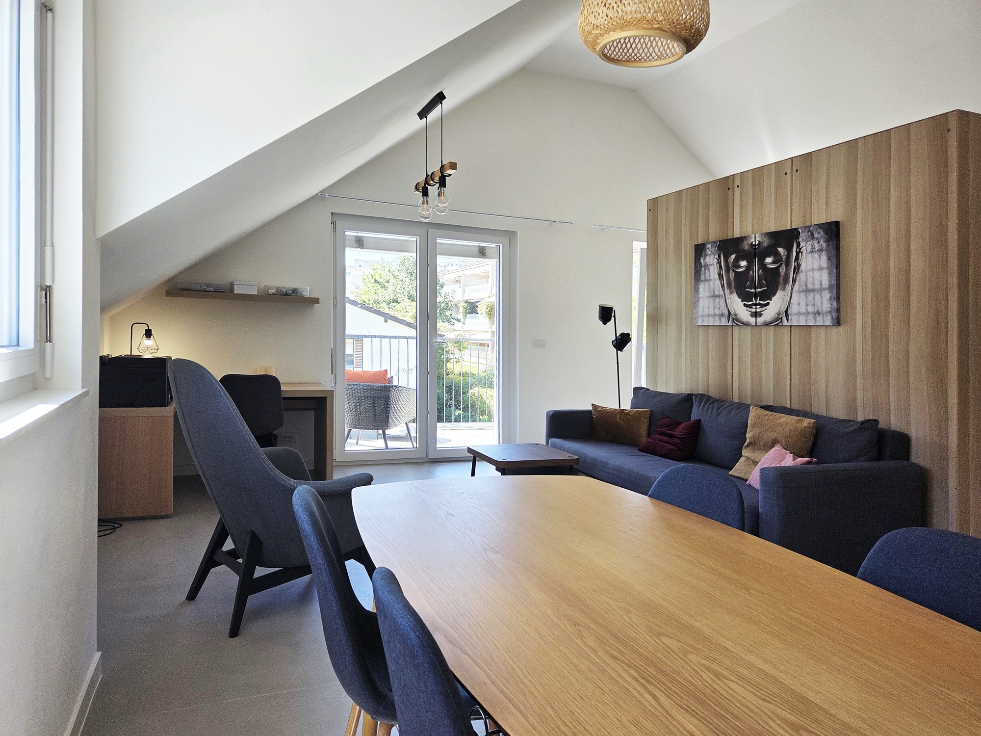 Grande pièce avec table à manger, coin bureau et accès au balcon